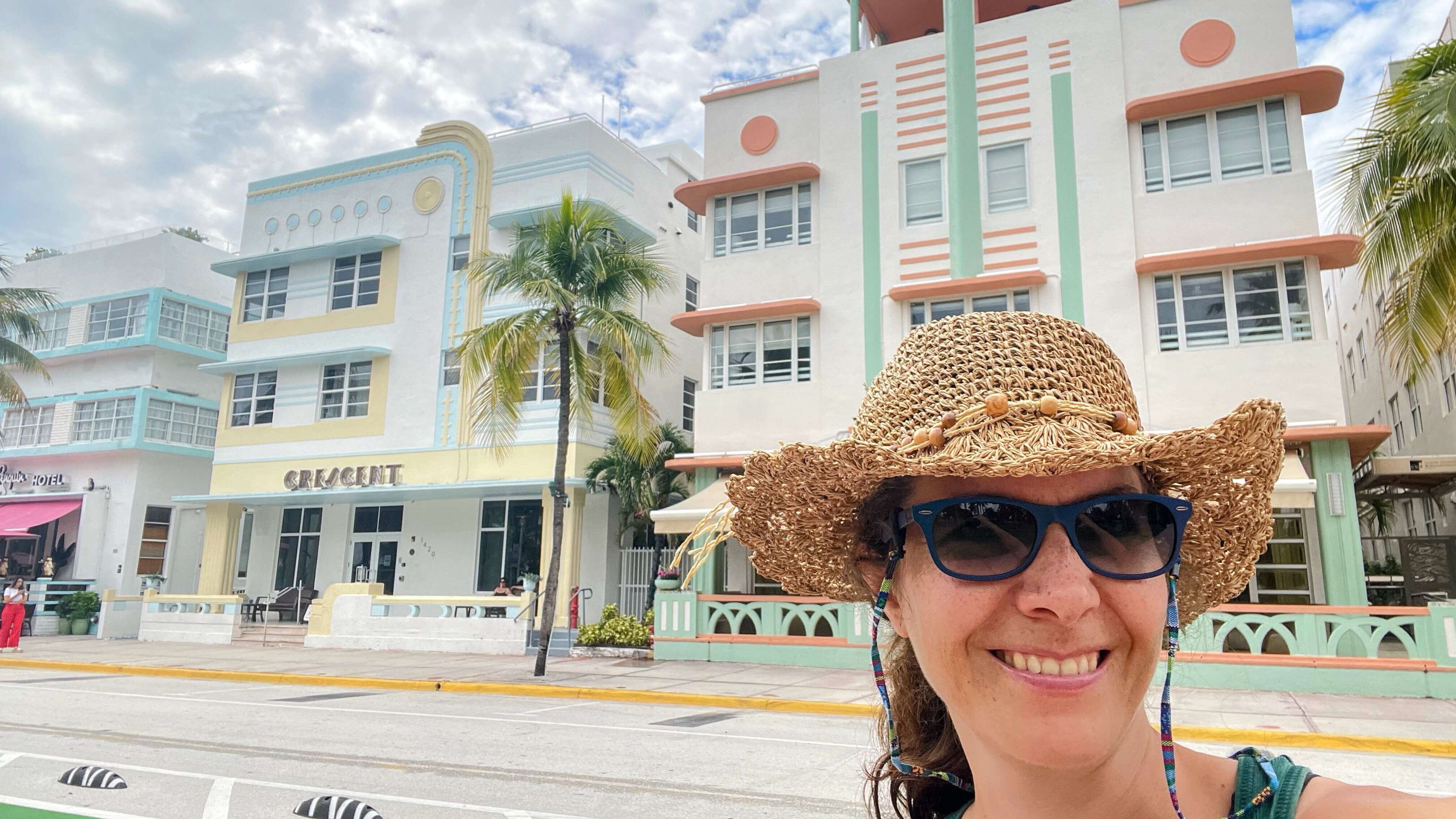 Sarah Lindner of Sarah's Lab smiling and making a selfie of herself. In the background you see the famous art-deco-style buildings of Miami Beach, Florida.